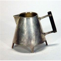 Silver plated Christopher Dresser designed triangular four footed cream jug with ebony handle, 8c…