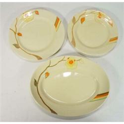 Three circular and an oval Clarice Cliff Bizarre plates, hand painted with yellow flowers, retail…