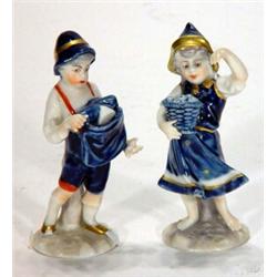 Pair of Continental porcelain figurines, hand painted with blue and gilt dresses clutching basket…