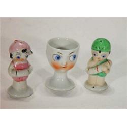 Hand painted goggle eyed porcelain salt and pepper and eggcup, tallest 7cm…