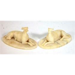 Pair of seated alabaster greyhounds on oval bases, 17cm in length…