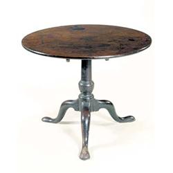 A George III mahogany tripod table, the round tilt top on a turned column and three cabriole legs...