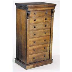 A William IV rosewood wellington chest, the seven graduated drawers with turned handles, flanked...