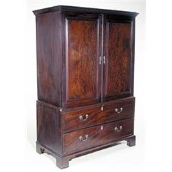 A mahogany wardrobe with a dentil cornice above two panelled doors, a false drawer and a long dra...