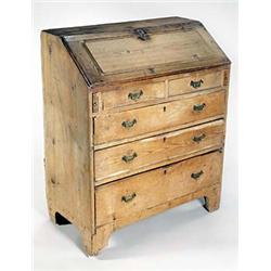 A pine bureau, the fall with reeded bands enclosing a fitted interior and a well, above two false...