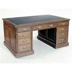 A late Victorian oak partners desk, the rectangular top with an inset and carved border above nin...