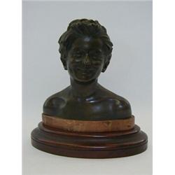 A BRONZE BUST, 20th Century, smiling boy, inscribed 'Vigo', mounted on an oval marble and mahogan...