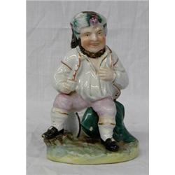 STAFFORDSHIRE POTTERY FIGURE, English. 19th Century. The jolly man sitting on a barrel holding...