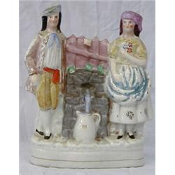 STAFFORDSHIRE POTTERY GROUP, English. 19th Century. Of a man and woman standing next to a well...