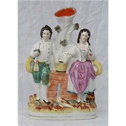 STAFFORDSHIRE POTTERY FIGURAL VASE, English. 19th Century. Of a man and woman standing next to...