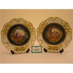 Pair of reticulated Meissen plates with central handpainted classical scenes, having gilt borders…
