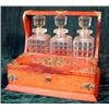 Image 1 : An Edwardian oak and brass mounted three bottle tantalus with twin hinged front compartments....