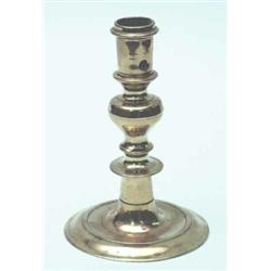 A French late 17th century brass candlestick, the baluster stem on circular foot with pierced eje...