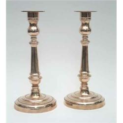 A pair of bell metal candlesticks of George III design, each with cylindrical stem and circular b...