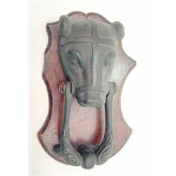 A 19th century bronze muzzled bear door knocker, the bears head and foliate cast knocker on a woo...