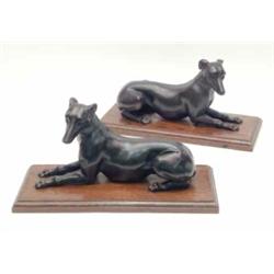 A pair of French 19th century cast-iron greyhounds, reclining on oak bases, 13ins long...