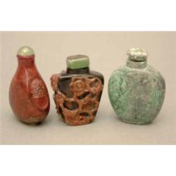 A dark chalcedony snuff bottle, carved in high relief using the reddish orange skin with flowerin...