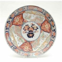A 19th century Imari porcelain charger, painted with flowers and fenced gardens in underglaze blu...
