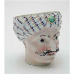 A German porcelain bust of a Turk, turban with jewel clasp, painted crossed swords mark, (wear to...