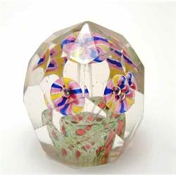 A faceted glass paperweight, with inset design of flowers within jardiniere, 3.5in...
