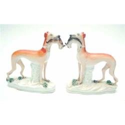 A pair of Victorian Staffordshire whippets, each holding rabbit in mouth, on moulded bases, 7.5in...