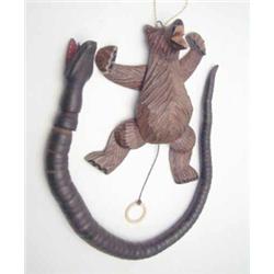 A Swiss carved pine bear with pull- cord jointed limbs (6.25ins) and a carved wood snake with ope...