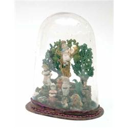 A 19th century carved wax group, children on a garden terrace with shrubs, under glass dome 8ins...