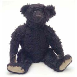A rare Steiff black plush teddy bear, circa 1915, boot button eyes with characteristic red felt s...