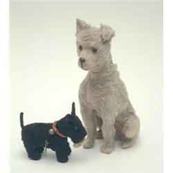 A clockwork terrier with wagging tail (4ins) and a blonde plush seated dog (8ins high)...