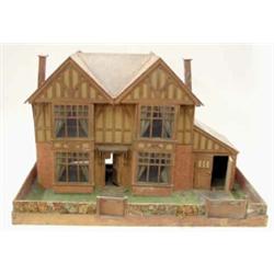 A double fronted mock Tudor half timber dolls house, with pitched roof and garage to side, within...