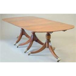 A George III design mahogany triple pillar dining table with 'D' ends, centre section and two ext...