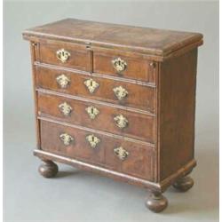 A walnut and feather banded bachelor's chest of Queen Anne design, with fold over top revealing g...