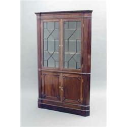 A George III mahogany standing corner cabinet, with dentil cornice and two astragal glazed doors...