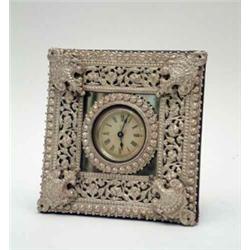 An Ansonia strut clock, with small printed paper dial, in silvered metal and mirrored frame, pate...