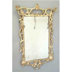 A Chippendale style carved giltwood mirror, the rectangular plate with pierced scrolling and trai...