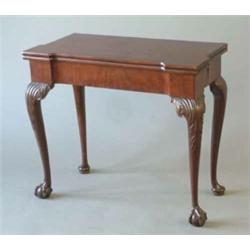 A George III mahogany card table on cabriole legs with acanthus carving to the front and claw and...