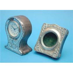 An Edwardian silver mounted timepiece, with Reynolds angel decoration and later movement, 5 ins....