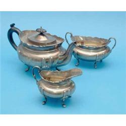 An Edwardian silver three piece tea set, of oval form with scroll feet, Birmingham 1905, Gross 38...