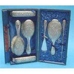 An Edwardian 7-piece silver dressing table set decorated with irises, in fitted case with associa...