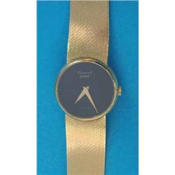 A ladys 18ct gold Choppard wrist watch, with black dial and flexible bracelet....