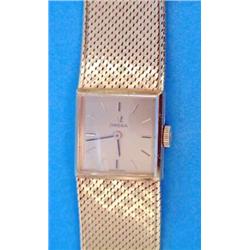 A ladys 18ct gold Omega wrist watch with integral flexible bracelet and square dial....