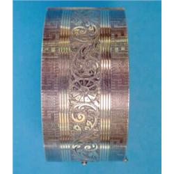 An Edward VIII silver gilt hinged bangle, the front with Greek key and foliate scroll decoration...