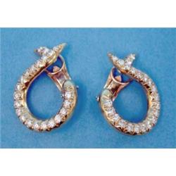 A pair of modern 18k gold diamond set earclips, of scroll design...