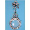 Image 1 : A late 19th century gold circular locket, the frame set clear pastes on a diamond set tied ribbon...