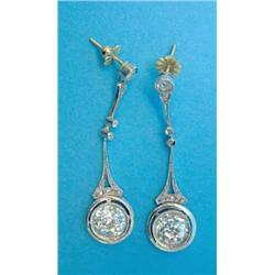 A pair of platinum and diamond drop earrings, each with a collet set round old brilliant cut diam...