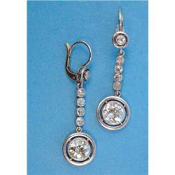 A pair of platinum and diamond drop earrings, each with a millegrain-set round old brilliant cut...