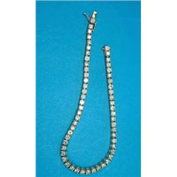 A 14k gold and diamond line bracelet, claw-set with 57 brilliant cut diamonds, (total diamond wei...