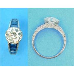 A platinum set diamond solitaire ring, the round old brilliant cut stone between tapered shoulder...