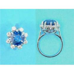 A white gold, sapphire and diamond cluster ring, the claw-set round cut sapphire (4.12cts) border...
