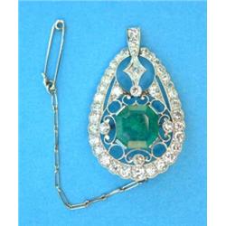 An Edwardian platinum, emerald and diamond pear shaped brooch, set with a square cut emerald with...